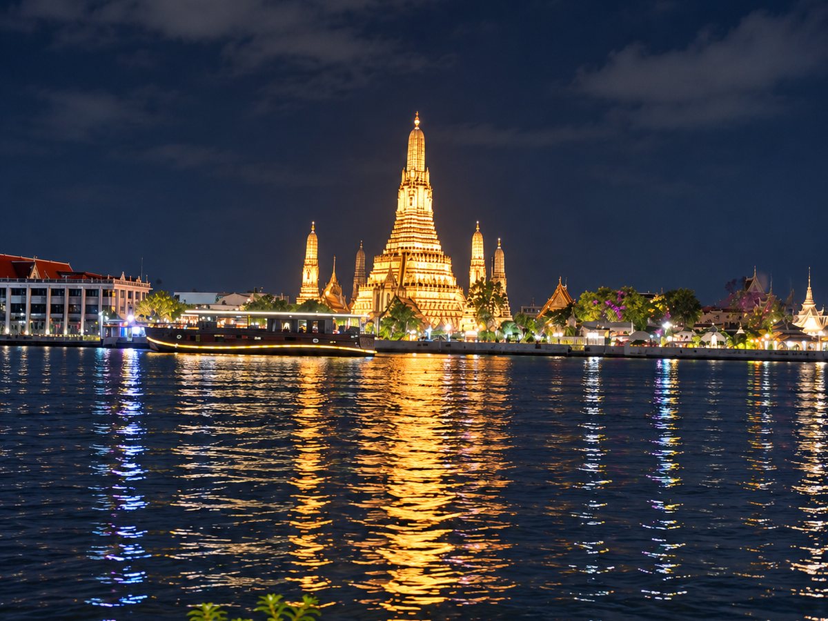 Wat Arun illuminé au bord du fleuve Chao Phraya, la nuit