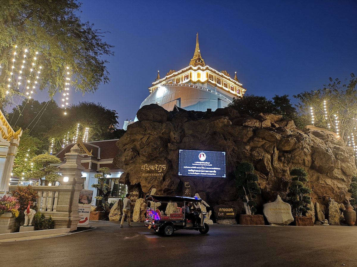 Wat Saket illuminé de nuit, avec un tuk-tuk au pied de la colline