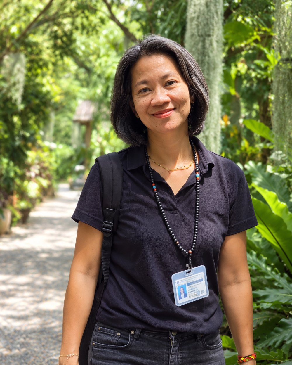 Tai, guide de Thaïlande Immersion, souriante dans un jardin tropical